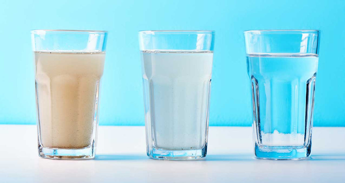 Drei Gläser im Vergleich: bräunlich trübes, milchig weißes und klares Wasser nebeneinander