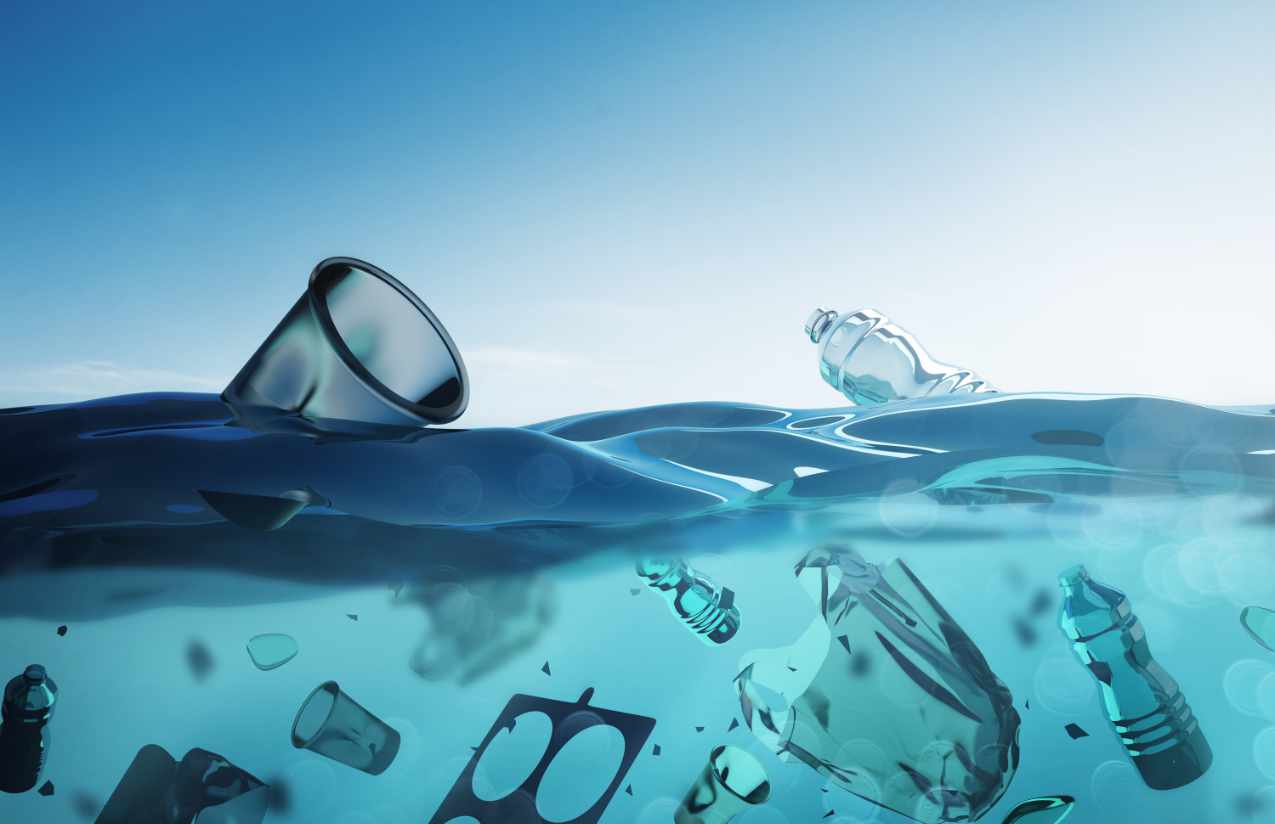 Plastikbecher und PET-Flaschen treiben an und unter der Wasseroberfläche